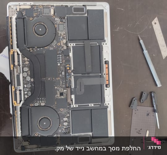 פנים מחשב נייד עם רכיבים אלקטרוניים וכלי עבודה